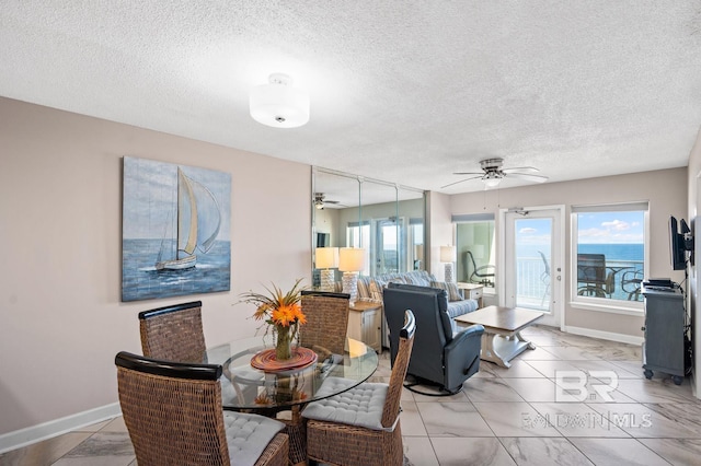 dining room with a textured ceiling and ceiling fan