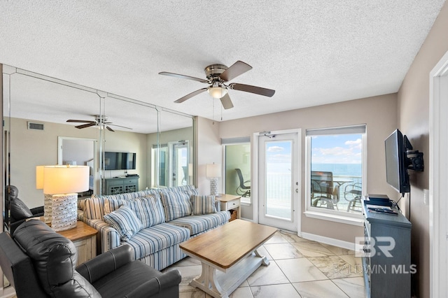 living room featuring a textured ceiling and ceiling fan