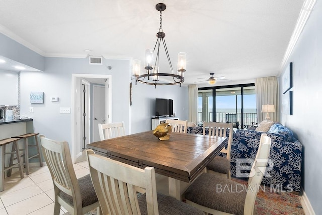 dining room with crown molding, light tile floors, and ceiling fan with notable chandelier