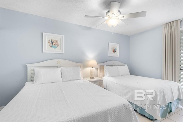 bedroom with a textured ceiling, ceiling fan, and light tile floors