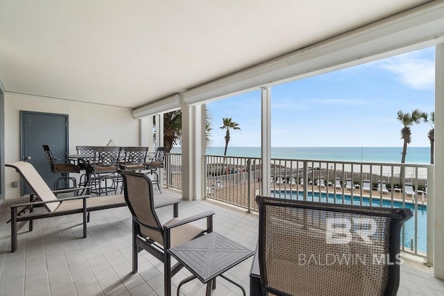 sunroom / solarium with a water view and a healthy amount of sunlight