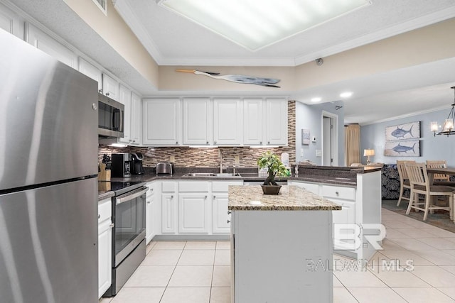 kitchen with appliances with stainless steel finishes, tasteful backsplash, sink, pendant lighting, and ornamental molding