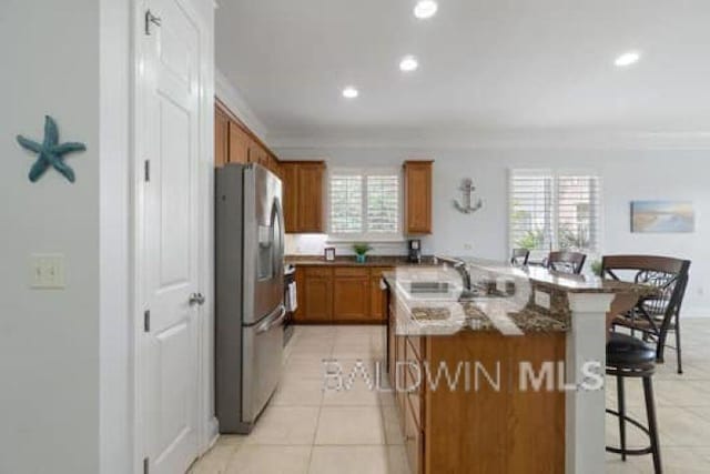 200 Peninsula Blvd Unit E101, Gulf Shores, AL 36542 - kitchen featuring stainless steel refrigerator with ice dispenser, brown cabinetry, a breakfast bar, crown molding, and recessed lighting