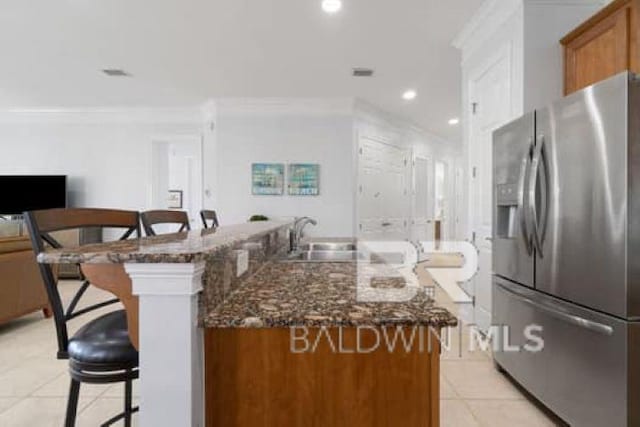200 Peninsula Blvd Unit E101, Gulf Shores, AL 36542 - kitchen with stainless steel fridge, a sink, a breakfast bar, light tile patterned floors, and crown molding