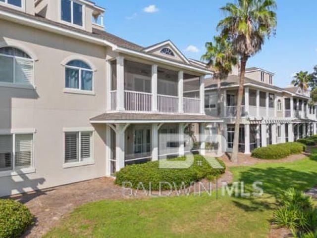 200 Peninsula Blvd Unit E101, Gulf Shores, AL 36542 - rear view of property featuring stucco siding and a lawn