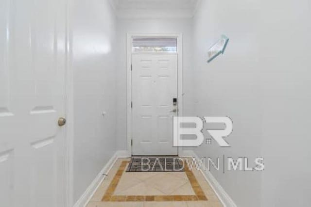200 Peninsula Blvd Unit E101, Gulf Shores, AL 36542 - doorway to outside with inlaid floor details, baseboards, and tile patterned flooring