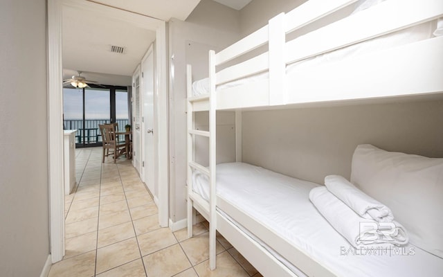 tiled bedroom featuring floor to ceiling windows