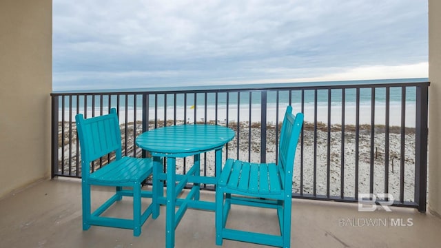 balcony featuring a water view and a view of the beach