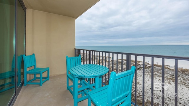 balcony featuring a water view and a beach view