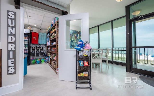 interior space featuring hardwood / wood-style floors, a paneled ceiling, expansive windows, and a water view