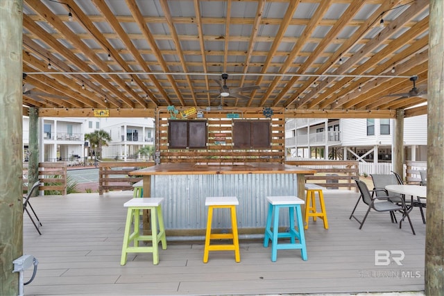 wooden terrace featuring a bar and ceiling fan