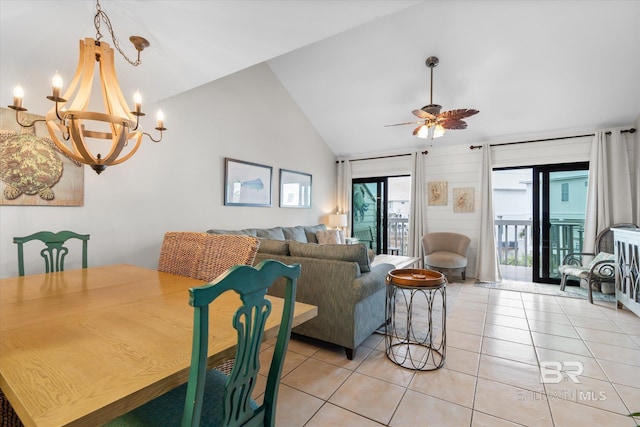 tiled dining space with ceiling fan with notable chandelier and high vaulted ceiling