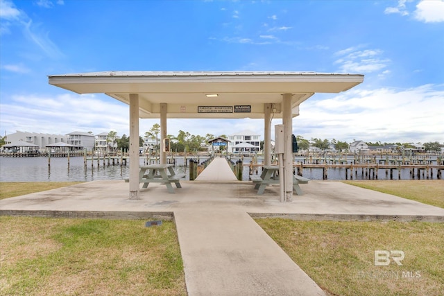 dock area with a yard and a water view