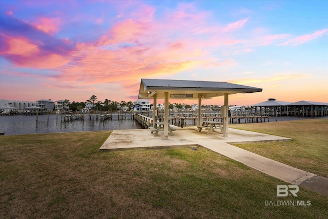 dock area featuring a water view and a lawn