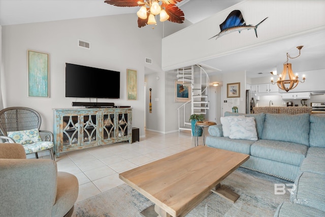 tiled living room featuring ceiling fan with notable chandelier and high vaulted ceiling