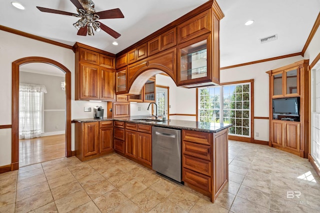 kitchen with stainless steel dishwasher, dark stone counters, kitchen peninsula, and ornamental molding