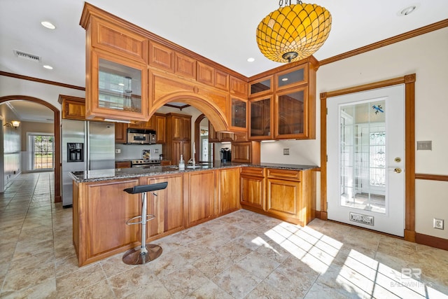 kitchen with appliances with stainless steel finishes, kitchen peninsula, a breakfast bar area, decorative light fixtures, and crown molding