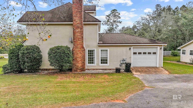 view of home's exterior with a garage and a yard