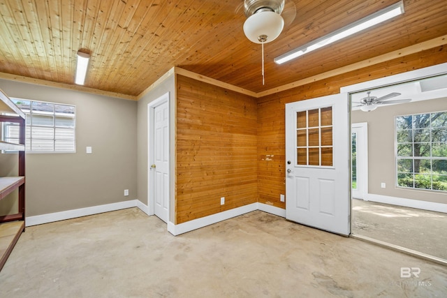 foyer featuring wooden walls, wooden ceiling, ceiling fan, and carpet