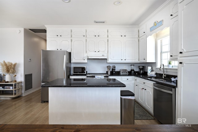 kitchen with visible vents, stainless steel appliances, white cabinets, and under cabinet range hood