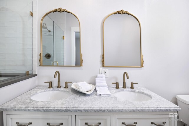 full bathroom featuring a stall shower, a sink, toilet, and double vanity