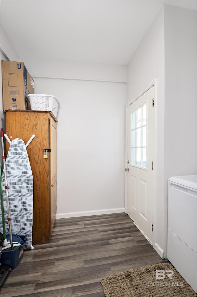 interior space with dark wood-style floors, washer / clothes dryer, and baseboards