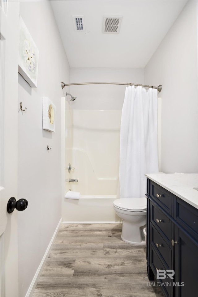 full bathroom featuring toilet, shower / tub combo, wood finished floors, vanity, and visible vents