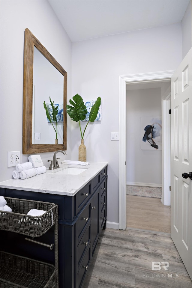 bathroom with vanity, baseboards, and wood finished floors