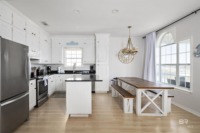 kitchen featuring visible vents, white cabinets, appliances with stainless steel finishes, light wood finished floors, and dark countertops