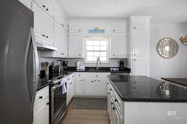 kitchen featuring white cabinets, under cabinet range hood, stainless steel appliances, and wood finished floors