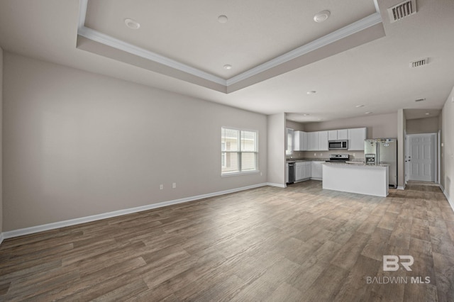24154 Veranda Cir, Elberta, AL 36530 - unfurnished living room with ornamental molding, a raised ceiling, wood finished floors, baseboards, and recessed lighting
