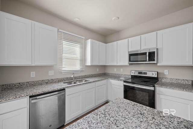 24154 Veranda Cir, Elberta, AL 36530 - kitchen featuring stainless steel appliances, a sink, white cabinetry, and light stone counters