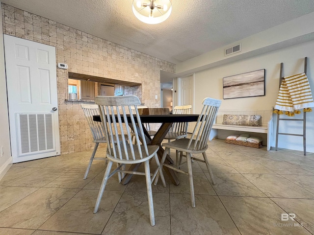 dining room with visible vents and a textured ceiling