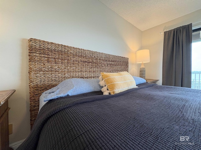 bedroom with vaulted ceiling and a textured ceiling