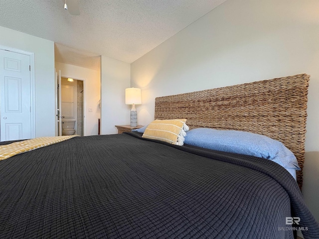 unfurnished bedroom with ensuite bath, vaulted ceiling, and a textured ceiling