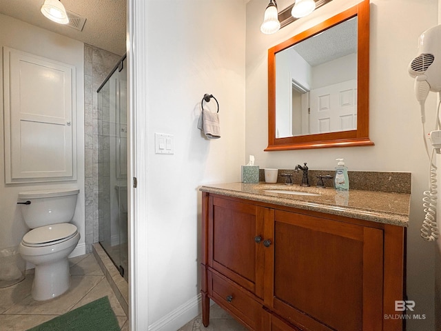 bathroom featuring toilet, a stall shower, tile patterned floors, a textured ceiling, and vanity