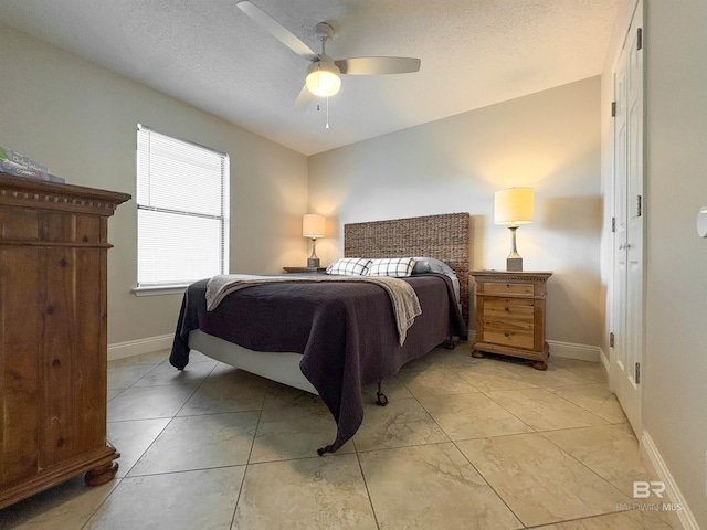 bedroom featuring ceiling fan, baseboards, and a textured ceiling