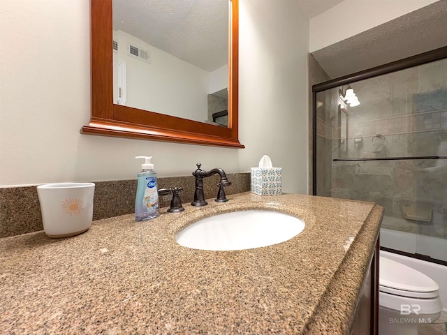 bathroom with visible vents, toilet, a textured ceiling, and vanity