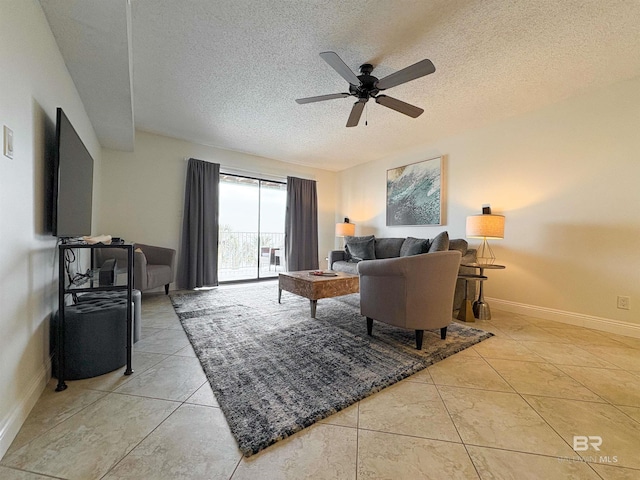 living area featuring light tile patterned floors, baseboards, a textured ceiling, and ceiling fan