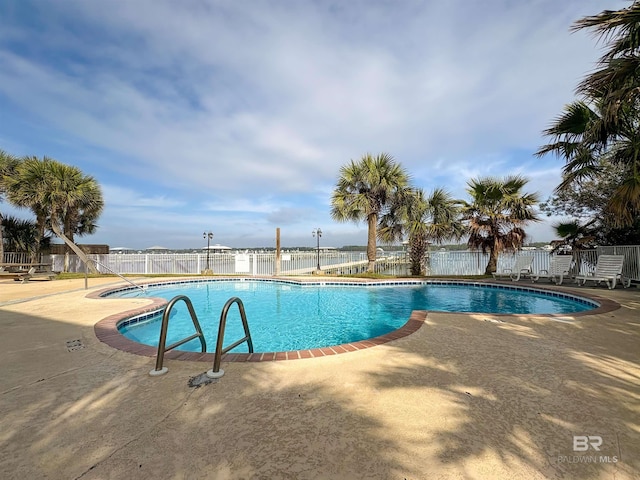 community pool featuring a patio and fence