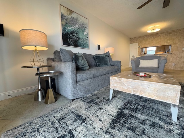 living area featuring a ceiling fan, baseboards, and a textured ceiling