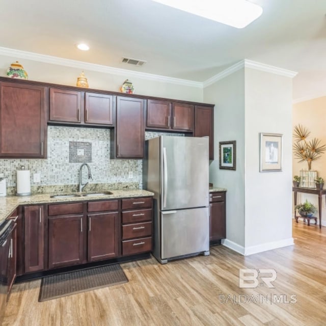 430 W Fort Morgan Rd Unit 1401, Gulf Shores, AL 36542 - kitchen with freestanding refrigerator, a sink, light wood-style flooring, light stone counters, and crown molding