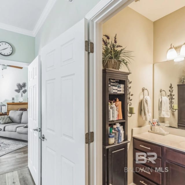 430 W Fort Morgan Rd Unit 1401, Gulf Shores, AL 36542 - bathroom with vanity, wood finished floors, and crown molding