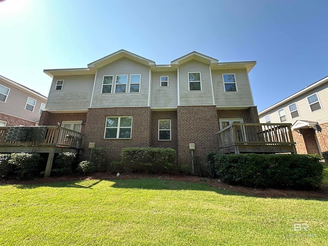 rear view of house featuring a deck and a lawn