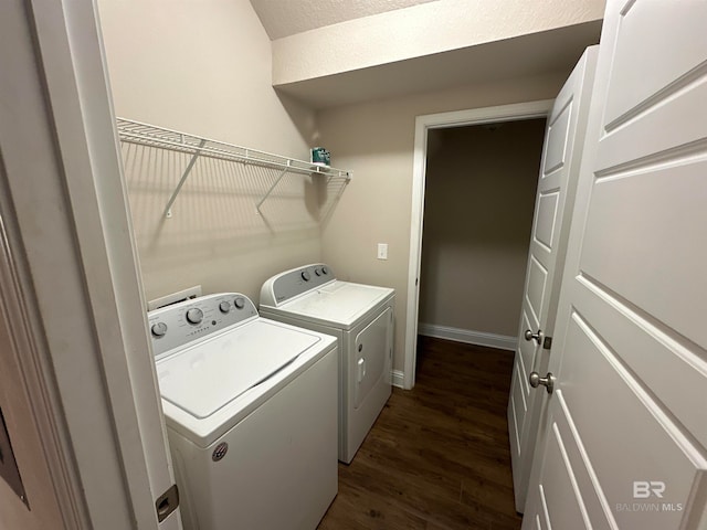 clothes washing area with dark wood-type flooring and washer and dryer