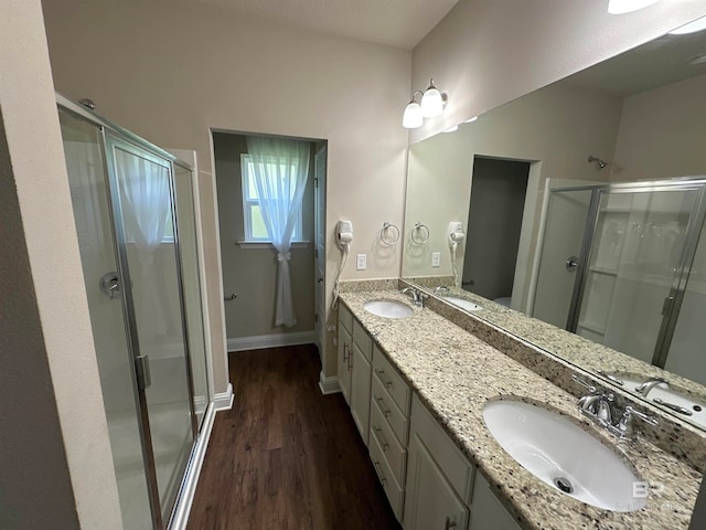 bathroom with vanity, hardwood / wood-style flooring, and a shower with shower door