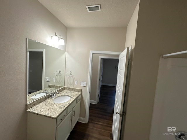 bathroom with vanity, a textured ceiling, and hardwood / wood-style flooring