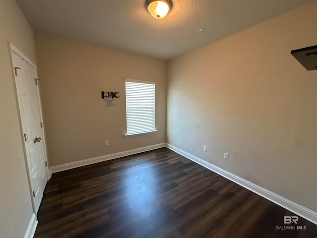 unfurnished room with dark hardwood / wood-style floors