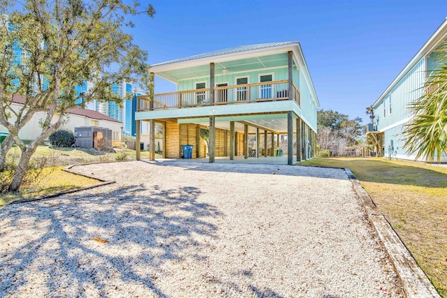 raised beach house with a carport, a front yard, and driveway