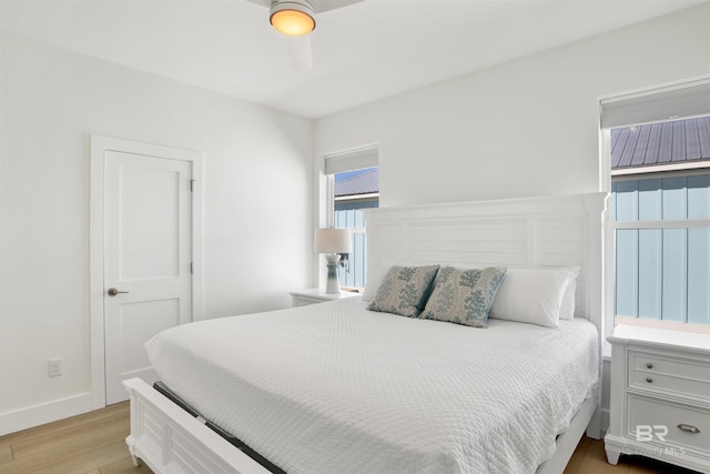 bedroom with light wood-type flooring and baseboards